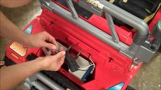 a person is working on an electrical device in a red case with metal pipes and wires attached to it