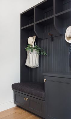 a black bench with a white bag hanging from it's back and some hats on top