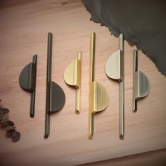 four different types of knives and spoons on a wooden surface with some rocks in the background