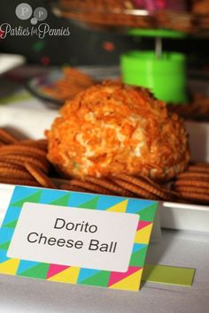 some food is sitting on a table with a name tag in front of it that says dorito cheese ball