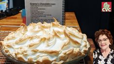 a woman standing next to a pie on a cooling rack