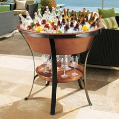 a table with wine glasses and bottles on it in front of an outdoor patio area