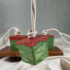 two soap bars sitting on top of a wooden board next to white string and rope