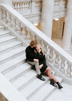 two people sitting on the steps of a building with their heads close to each other