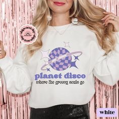 Get ready to boogie on the dance floor with our Disco collection. This retro-inspired collection is a funky and stylish addition to any wardrobe, perfect for those who love to dance and get groovy. Whether you're heading to a 70s disco-themed party or just want to add some fun and funkiness to your everyday wardrobe, our Disco collection is the perfect choice.  Featuring bold and playful graphics, this collection is sure to turn heads and get the party started. Choose from a range of styles from western cowgirl to disco themed, we have it all! Our fabric is breathable, allowing you to dance and party the night away without feeling restricted. At our small business, we take pride in creating high-quality products that are both stylish and affordable. Shop with us today and discover the perf Retro Slogan Top For Concerts, Retro Slogan Tops For Concerts, Retro Graphic Print Sweatshirt For Concerts, Retro Fall Concert Tops, Retro Fall Tops For Concert, Retro Tops For Fall Concerts, Retro Long Sleeve Slogan T-shirt, Groovy Cotton Tops For Streetwear, Disco Style Crew Neck Tops With Letter Print