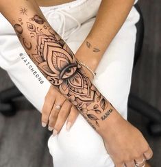 a woman's arm with an intricate tattoo design on her left forearm and wrist