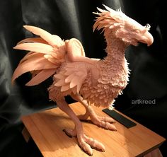 a sculpture of a bird on a wooden table