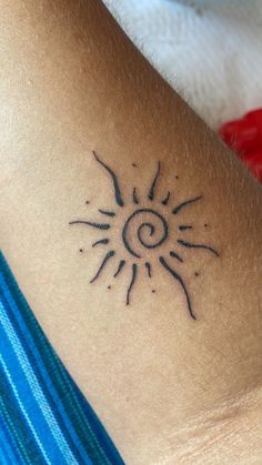 a small sun tattoo on the back of a woman's left arm and shoulder