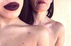 two women with lipstick on their faces and one has a heart tattooed on her chest