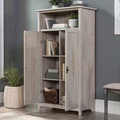 an open bookcase with books and plants on it in a room next to a chair