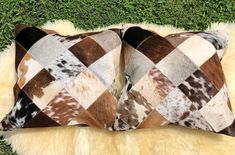 two brown and white pillows sitting on top of a fur rug