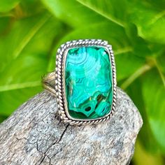 Malachite Chrysocolla Sterling Silver Ring This stunning green and blue  malachite Chrysocolla (Arizona) gem is set in a sterling silver setting with roped detail.  Guaranteed to garner lots of compliments!  Sized at 7 and marked 925. I do not offer resizing for rings. The reason for this is that in order to resize a ring I must remove the stone from the setting in order to remove the band from the backplate for resizing. This is very time consuming and entails a risk of damage to the bezel and possibly the stone so for me it is just too risky.  Every piece of jewelry is crafted with a very close attention to detail. Each item will have its own character which is what makes them unique. Most jewelry stores will happily measure your finger size. A great resource for getting your own ring si Green Turquoise Ring With Natural Stones, Green Malachite Bohemian Jewelry, Green Malachite Rings As A Gift, Adjustable Green Turquoise Chrysocolla Ring, Artisan Green Rings With Large Stone, Green Chrysocolla Rings With Natural Stones, Artisan Chrysocolla Gemstone Rings, Artisan Green Chrysocolla Rings, Green Rectangular Spiritual Jewelry