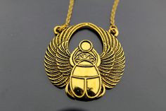 "Gold Scarab Charm Necklace, Egyptian Scarab Pendant, Scarab Charm, Egyptian Jewelry, Gold Necklace, Personalized Necklace, Customized Jewelry Gold scarab pendant charm necklace charm on high quality stainless steel chain. ♥ You will receive 1 necklace ♥ Charm Measurement Approx: 42 mm x 41 mm (1 5/8\" x 1 5/8\") ♥ Zinc Metal Alloy Pendants, Egyptian Scarab Gold Tone, Antique Gold ♥ Choose chain length from drop down menu. ♥ Shipping: A flat rate in the United States, regardless of how many item Handmade Gold Metal Charm Necklaces, Nickel-free Gold Brass Charm Necklaces, Gold Symbolic Metal Necklaces, Symbolic Gold Metal Necklace, Bronze Metal Charm Necklace Gift, Bronze Metal Charm Necklace For Gift, Handmade Gold Brass Charm Necklaces, Symbolic Gold Charm Necklaces Nickel Free, Cadmium-free Brass Pendant Necklace