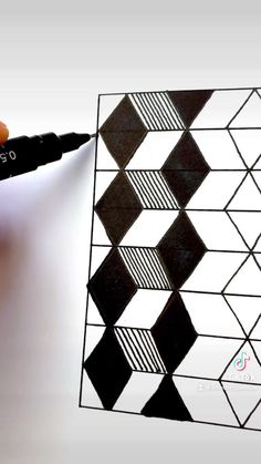 a person is drawing on a piece of paper with black and white squares in the background