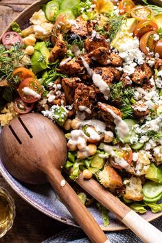 a salad with chicken, tomatoes, cucumbers and feta cheese on top