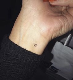 a small star tattoo on the wrist