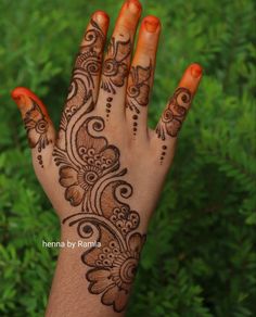 the hand is decorated with henna on it and has an intricate flower design in the middle