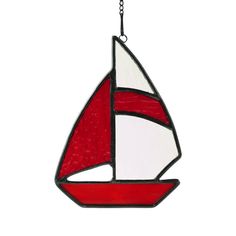 a stained glass sailboat ornament hanging from a chain