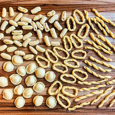 pasta shells and other food items on a wooden surface, including one with spirals