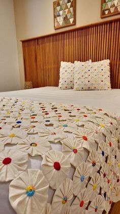 a bed with white bedspread and wooden headboard