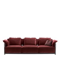 a red couch with pillows on it and a white wall in the backround