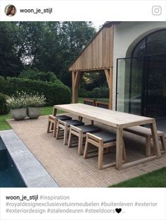 a wooden table and chairs in front of a pool