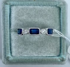 Classy Blue sapphire and diamond Band White Gold.  Excellent craftsmanship, all stones are inset so won't catch on things.  The emerald cut sapphires are nice sizes.  The diamonds sparkles nicely.  This band is stunning worn by itself or stack with other rings.  About 3.8mm width.   Genuine Earth Mined sapphires Total weight: 1.16 carats Beautiful dark blue color Genuine earth mined round brilliant cut diamonds  Total weight: 0.21 carats  Clarity: SI Color: F/G Solid 18K white gold 2.95 grams  Stock ring size 6.5 Comes with gift box Emerald Cut Multi-stone Sapphire Ring With Diamonds, Multi-stone Sapphire Ring Baguette Cut, Blue Sapphire Ring With Multi-stone Baguette Cut, Blue Sapphire Multi-stone Baguette Ring, Rectangular Brilliant Cut Sapphire Ring, Blue Multi-stone Baguette Cut Sapphire Ring, Emerald Cut Sapphire Multi-stone Jewelry, Emerald-cut Sapphire Multi-stone Jewelry, Emerald Cut Lab-created Sapphire Ring With Diamond Accents