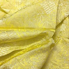 yellow fabric with white and gold designs on the top, as well as other material