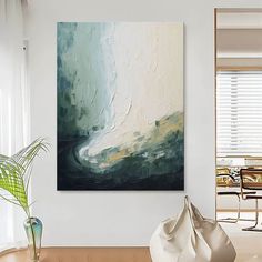 an abstract painting hangs on the wall above a table