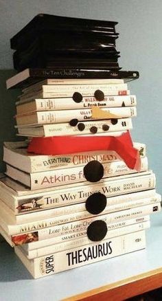 a stack of books sitting on top of a wooden table next to a blue wall