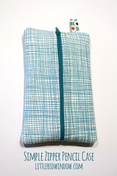 the zipper pencil case is blue and white checkered fabric, with a small button at the top