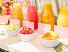 there are many different types of juices on the table with name tags in front of them