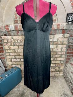 vanity fair negligee slip Vintage black nightgown Size 34 L 100% nylon Be aware that vintage sizes may vary from modern standard sizes. See the sizely chart in the product photos for full measurements. The measurements are the most accurate gauge of the garments size. chest, waist and hip measurements are taken laying flat and then doubled. all measurements are approximate.  Vintage items are carefully inspected and I do my best to describe all flaws. but all vintage items may have unnoticed flaws and signs of wear from being preloved. Full measurements are listed so we do not accept returns for fit. Black Lace Trim Camisole Slip Dress, Black Camisole Slip Dress With Lace Trim, Black Satin Camisole Slip Dress, Fitted Black V-neck Nightgown, Black Satin Slip Dress For Daywear, Black Camisole Slip Dress For Evening, Black Sleeveless Satin Nightgown, Black Nightgown With Lace Trim And Spaghetti Straps, Black V-neck Evening Nightgown