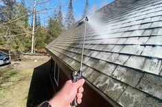 a person spraying water on the roof of a house