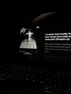 a laptop computer sitting on top of a desk in front of a dark background with words written across the screen