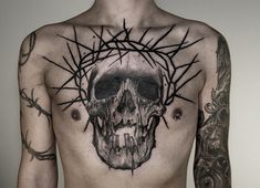 a man with tattoos on his chest has a skull and thorns tattoo on his back