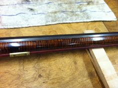 a wooden pen sitting on top of a table next to a piece of wood and cloth