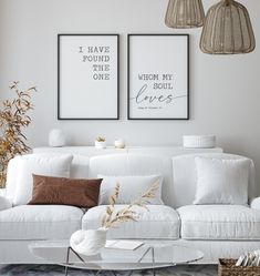 two framed pictures above a white couch in a living room