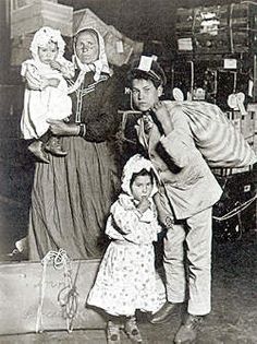 an old black and white photo of three people with two babys in their arms