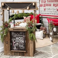 a christmas display in the corner of a room with decorations on it and a sign that says welcome to hot cocoa