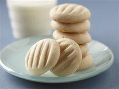 some cookies are sitting on a plate next to a glass of milk