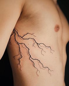 a man's bare chest with a lightning bolt tattoo on it