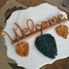 a sign that says welcome with some leaves on it