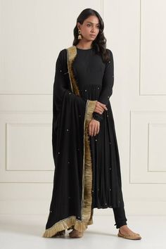 Black wrinkled cotton anarkali with churidar sleeves, gathered flare, all over metallic sequin and zari embroidery. Paired with gathered churidar and embroidered dupatta with kiran fringe lace border.
Components: 3
Pattern: Hand Embroidered 
Type Of Work: Sequin, Zari and Lace Work
Neckline: Round Neck
Sleeve Type: Churidar Sleeves
Fabric: Wrinkle Cotton
Color: Black
Other Details: 
Deep round back
Closure:
Anarkali: Back tasselled tie-up
Churidar: Elasticated waistband
Occasion: Sangeet - Aza F Cotton Silk Floor-length Churidar With Dupatta, Floor-length Cotton Silk Churidar With Dupatta, Cotton Silk Maxi Salwar Kameez For Eid, Cotton Silk Maxi Salwar Kameez For Diwali, Cotton Silk Maxi Length Salwar Kameez For Eid, Anarkali Style Cotton Silk Churidar With Dupatta, Festive Gota Work Maxi-length Dupatta, Gota Work Maxi Length Dupatta For Eid, Diwali Cotton Silk Maxi Salwar Kameez