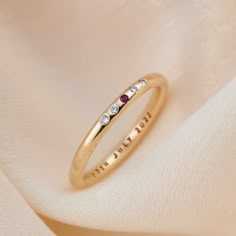 a gold ring with three stones on it and the word love written in cursive writing