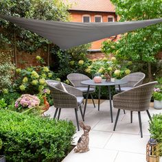 an outdoor dining table and chairs in a garden