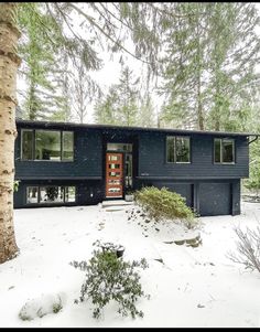 a house in the woods with snow on the ground