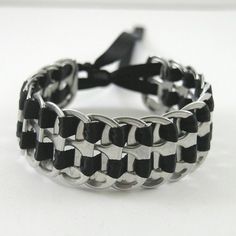 a black and white braided bracelet with metal clasps on a white table top