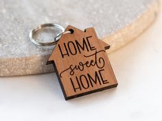 a wooden keychain with the words home sweet home written in black on it