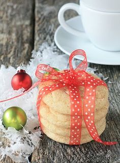 a white cup and saucer sitting on top of a wooden table next to christmas decorations